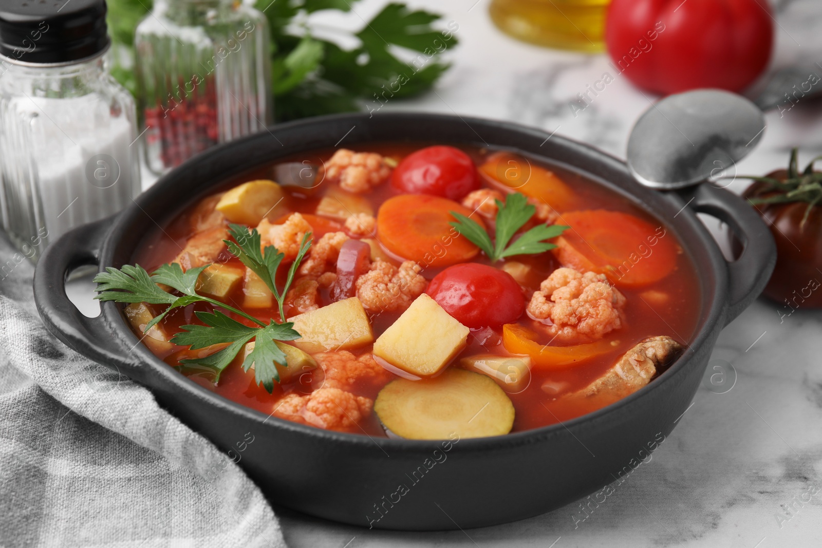 Photo of Tasty homemade stew with vegetables on white marble table, closeup