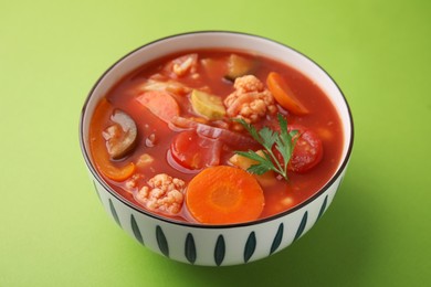 Tasty homemade stew with vegetables on light green table, closeup