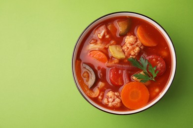 Photo of Tasty homemade stew with vegetables on light green table, top view. Space for text