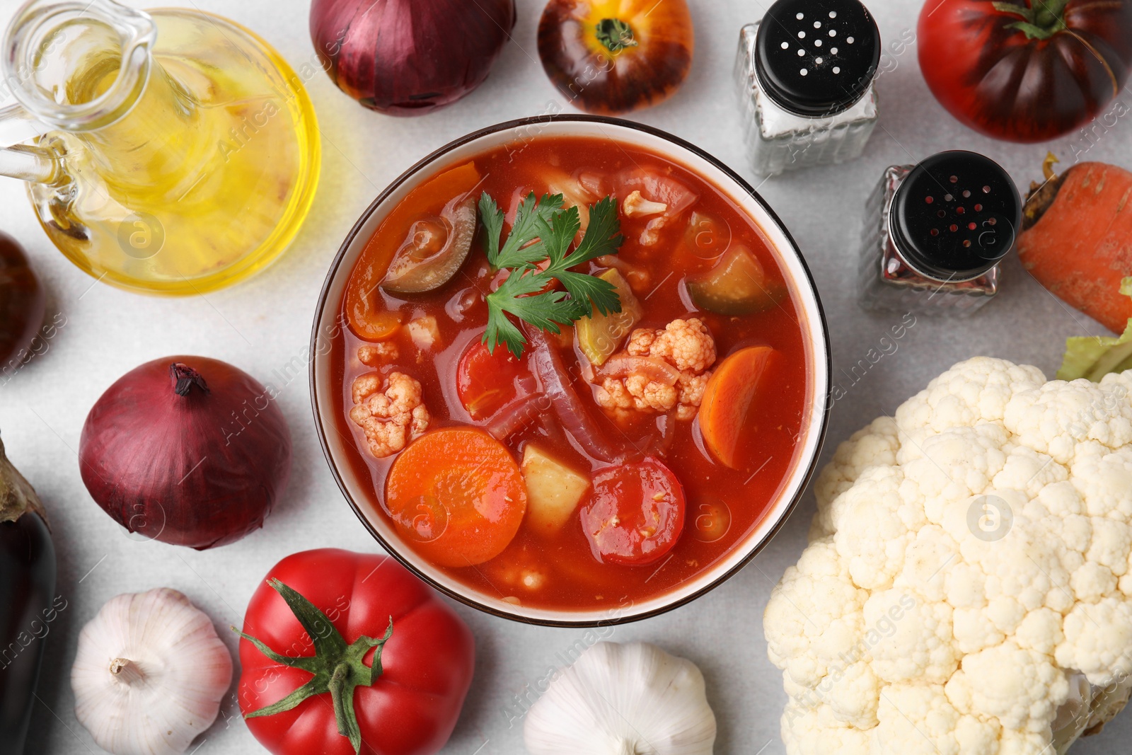 Photo of Tasty homemade stew with vegetables on white table, flat lay