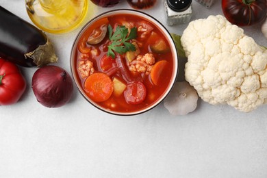 Photo of Tasty homemade stew with vegetables on white table, flat lay. Space for text