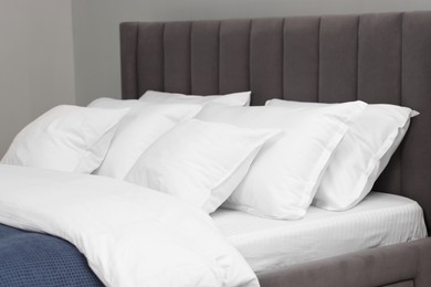 Photo of Many soft pillows on bed at home