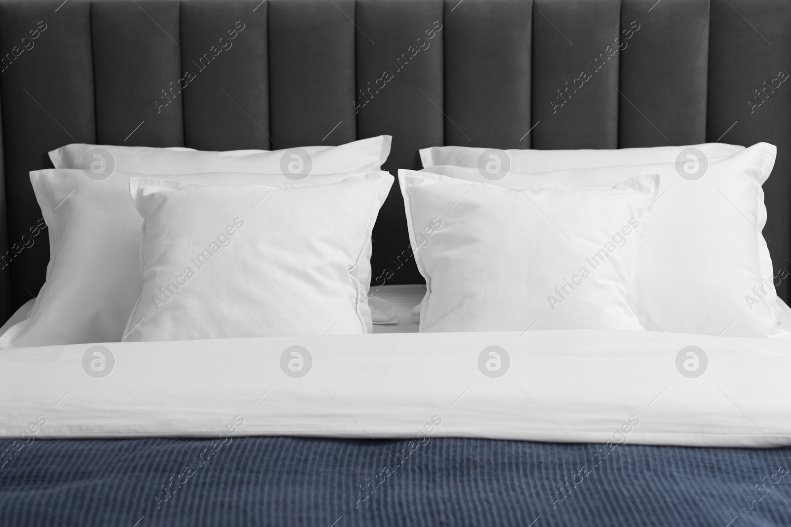 Photo of Many soft pillows on bed at home