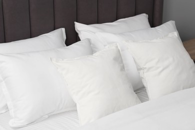 Many soft pillows on bed at home, closeup