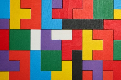 Photo of Colorful wooden puzzle pieces as background, top view