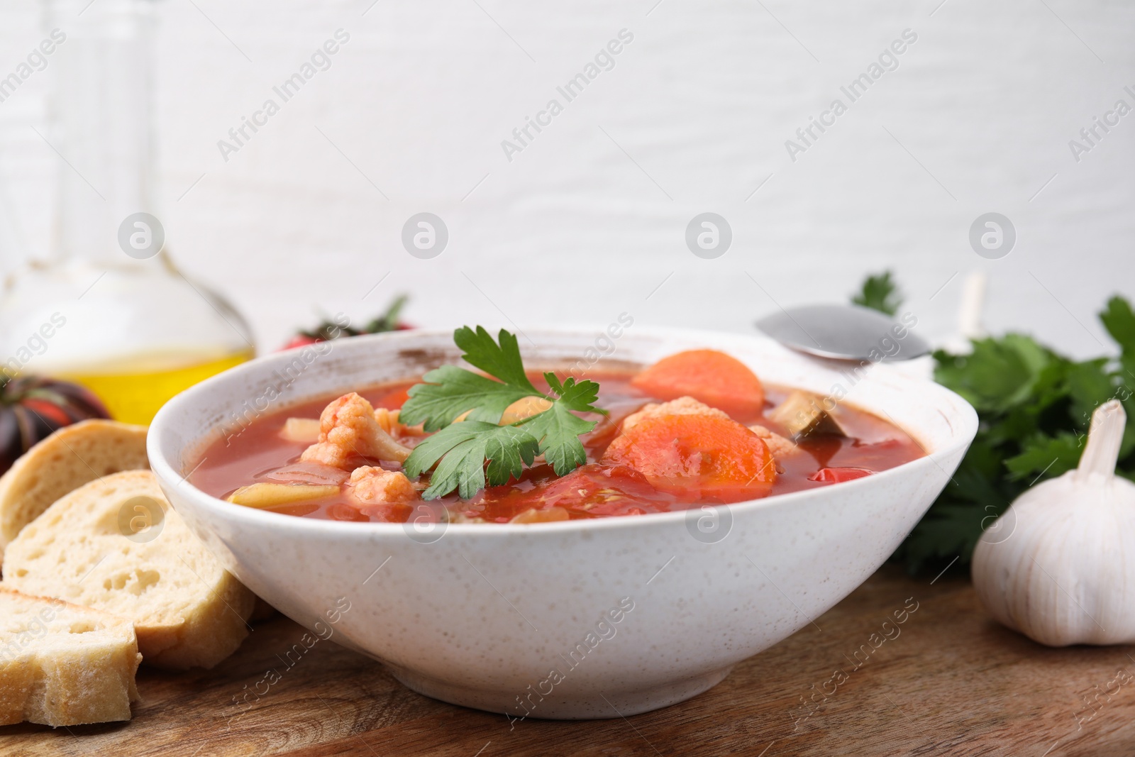 Photo of Delicious homemade stew in bowl and bread on table