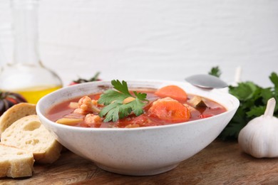 Delicious homemade stew in bowl and bread on table