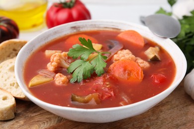 Photo of Delicious homemade stew in bowl and bread on table, closeup