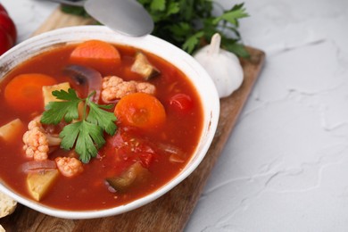 Delicious homemade stew in bowl on light table, closeup. Space for text