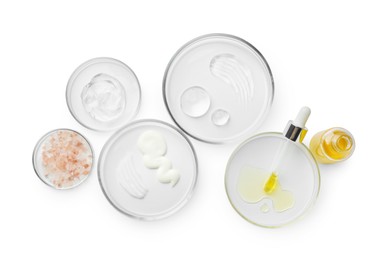 Photo of Petri dishes with different cosmetic products isolated on white, flat lay