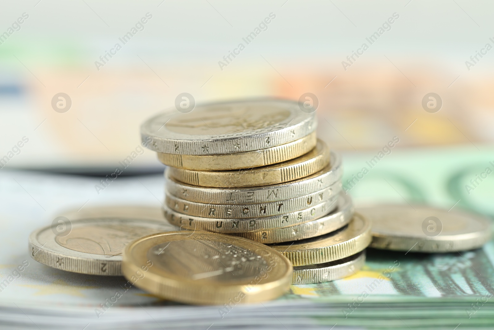 Photo of Many coins on euro banknotes, closeup view