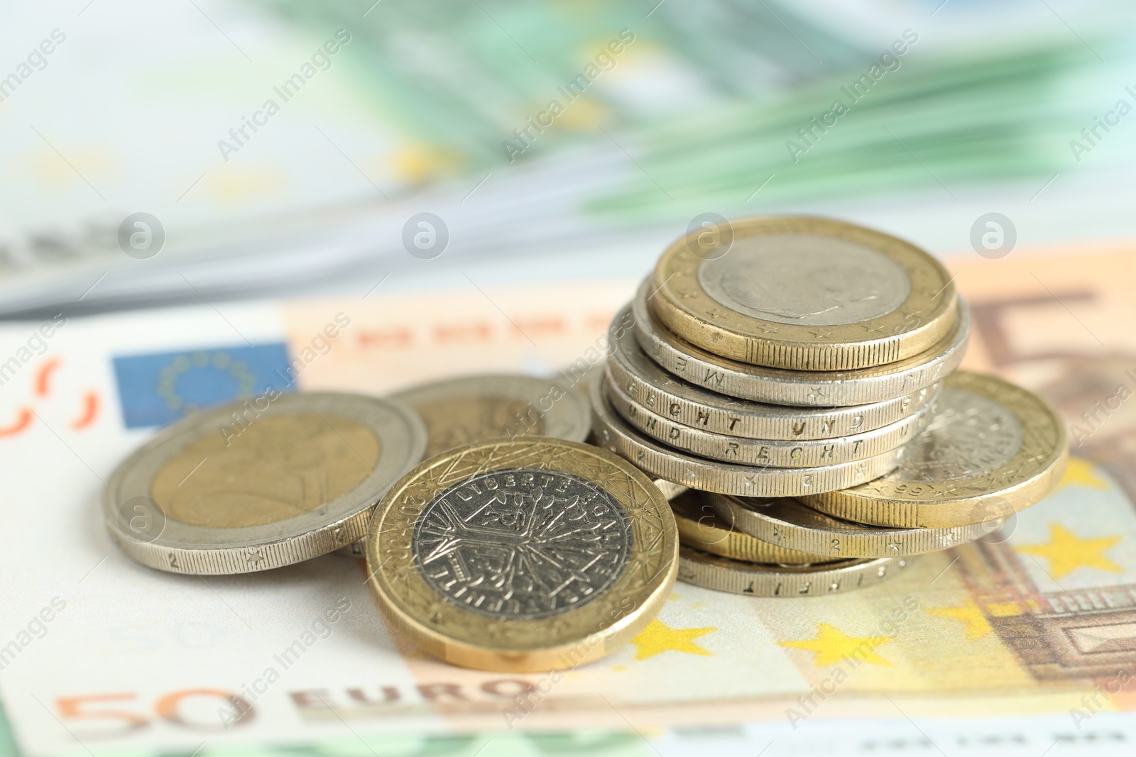 Photo of Many coins on euro banknotes, closeup view