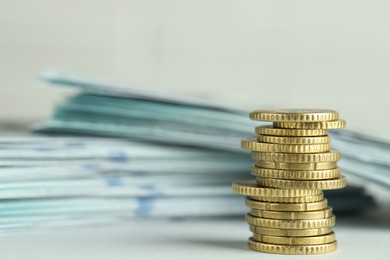 Photo of Stack of euro coins and banknotes on light grey background