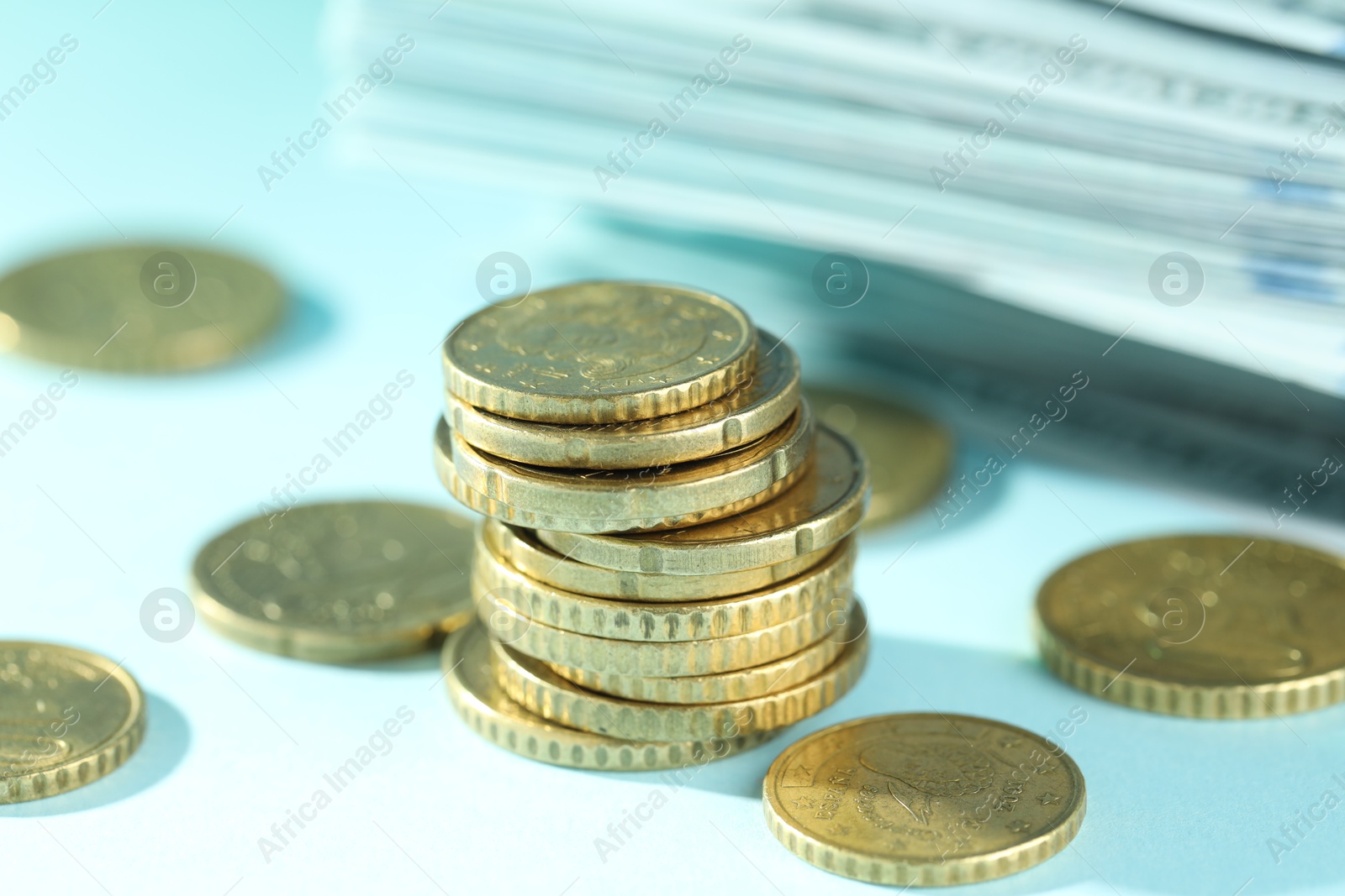 Photo of Stack of euro coins on light blue background, closeup