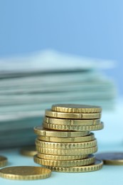 Stack of euro coins on light blue background, closeup