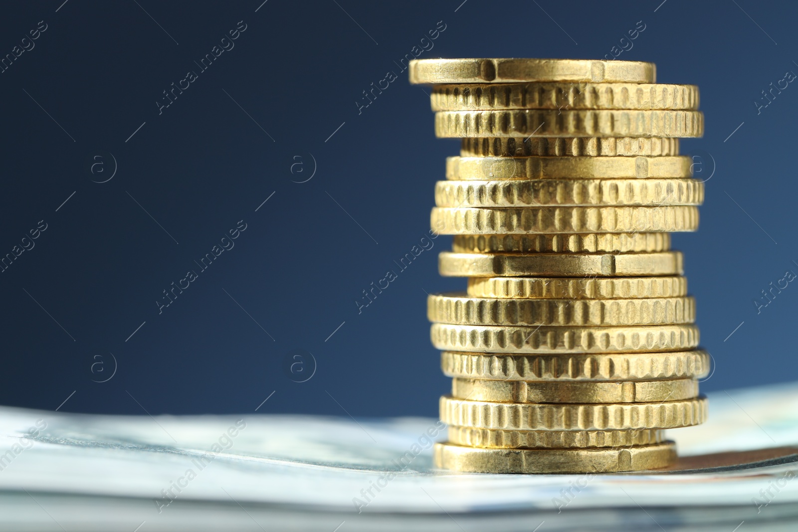 Photo of Stack of euro coins on blue background, closeup. Space for text