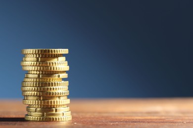 Photo of Stack of euro coins on wooden table, space for text