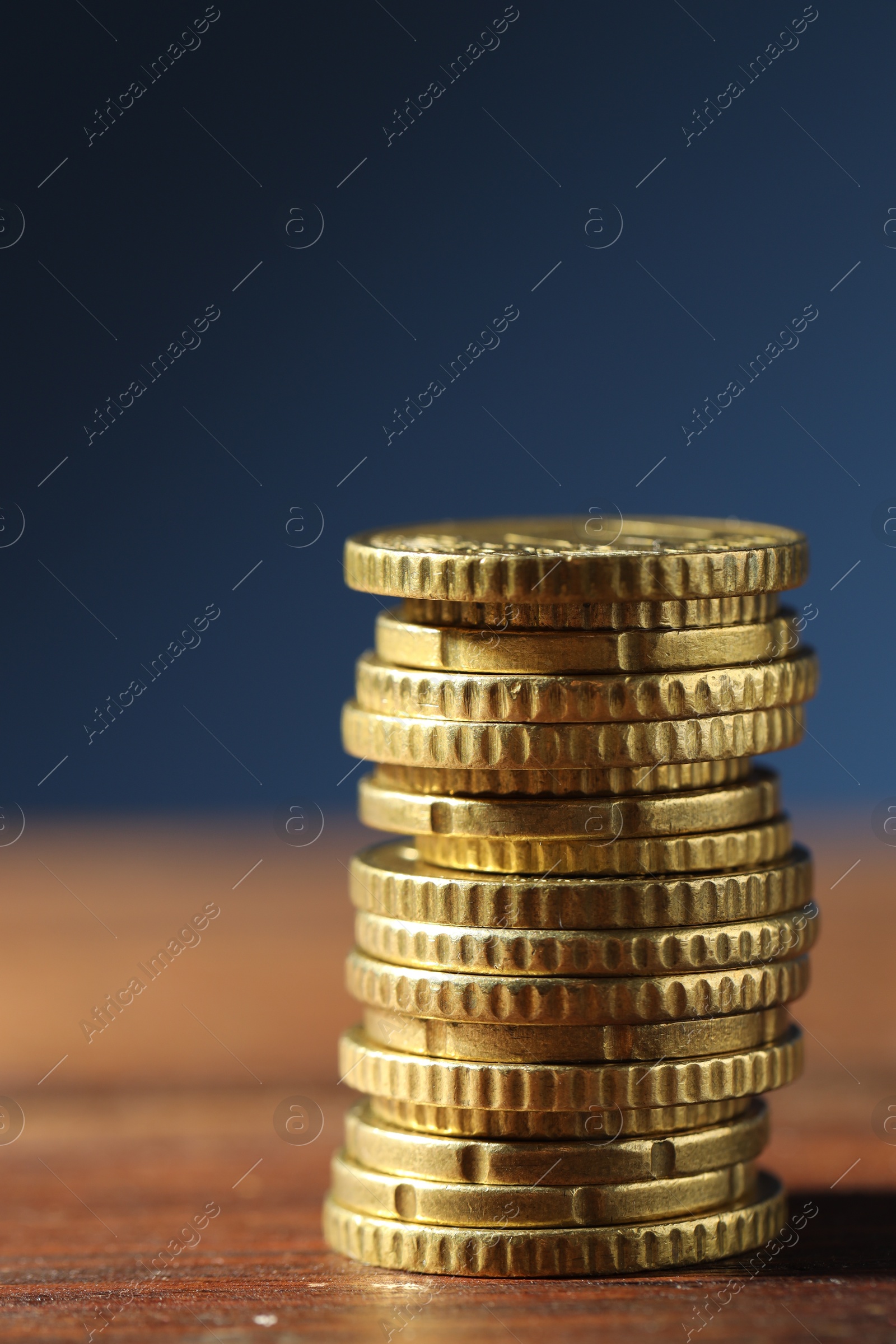 Photo of Stack of euro coins on wooden table, closeup