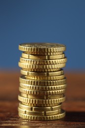 Stack of euro coins on wooden table, closeup