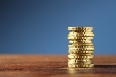 Photo of Stack of euro coins on wooden table, space for text