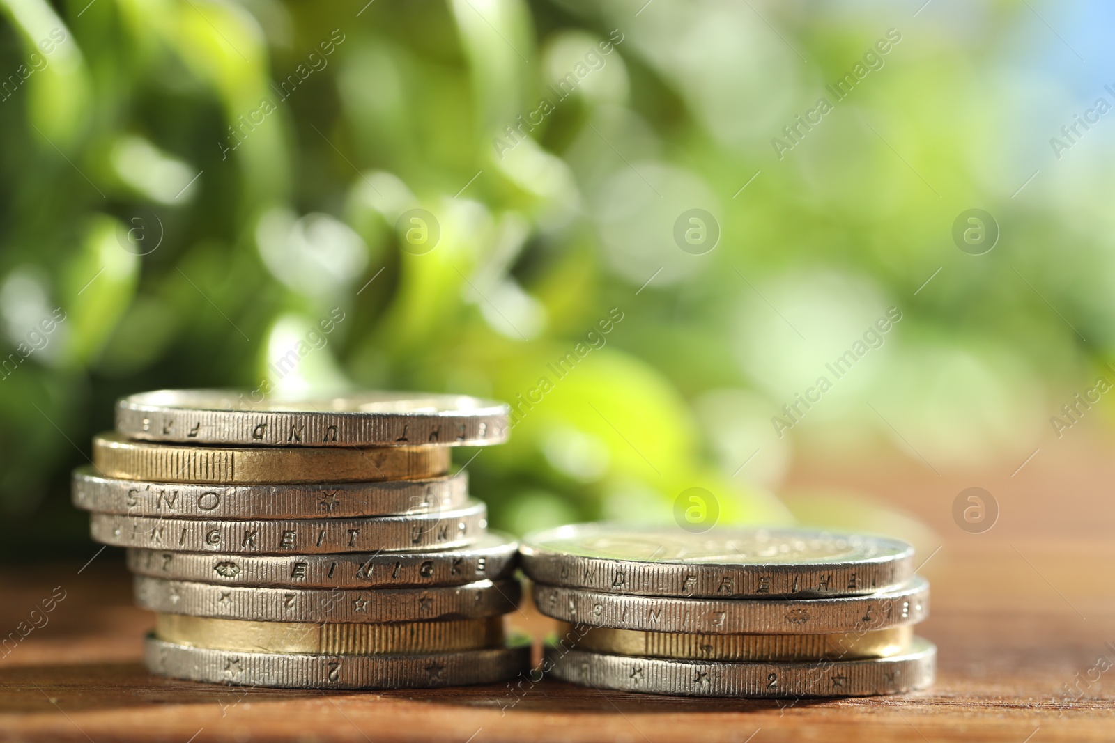 Photo of Stacked euro coins on wooden table, closeup