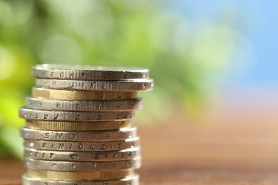 Photo of Stacked euro coins on blurred background, closeup. Space for text