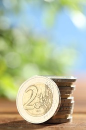 Stacked euro coins on wooden table, closeup