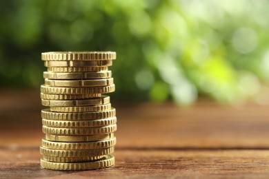 Stacked euro coins on wooden table, space for text