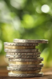 Photo of Stack of euro coins on wooden table, closeup