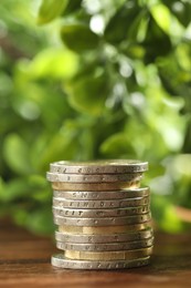 Photo of Stack of euro coins on wooden table