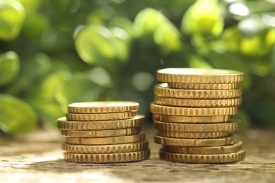 Photo of Stacked euro coins on wooden table outdoors