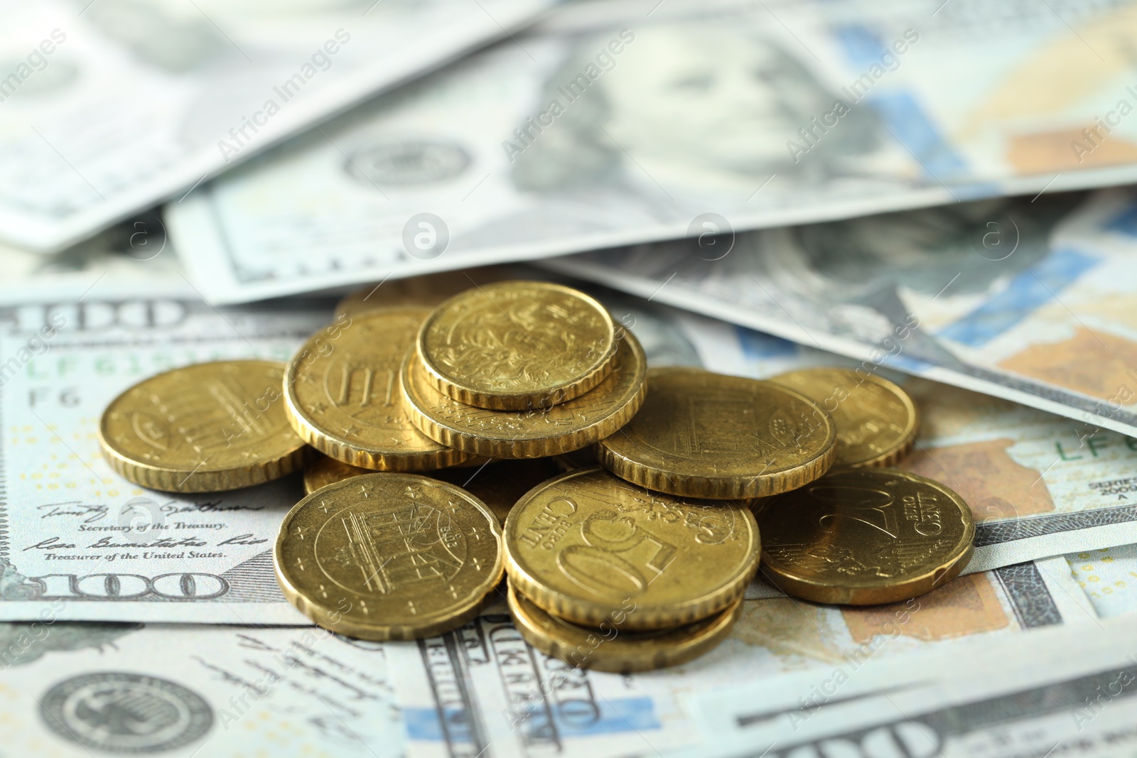 Photo of Many euro coins on dollar banknotes, closeup