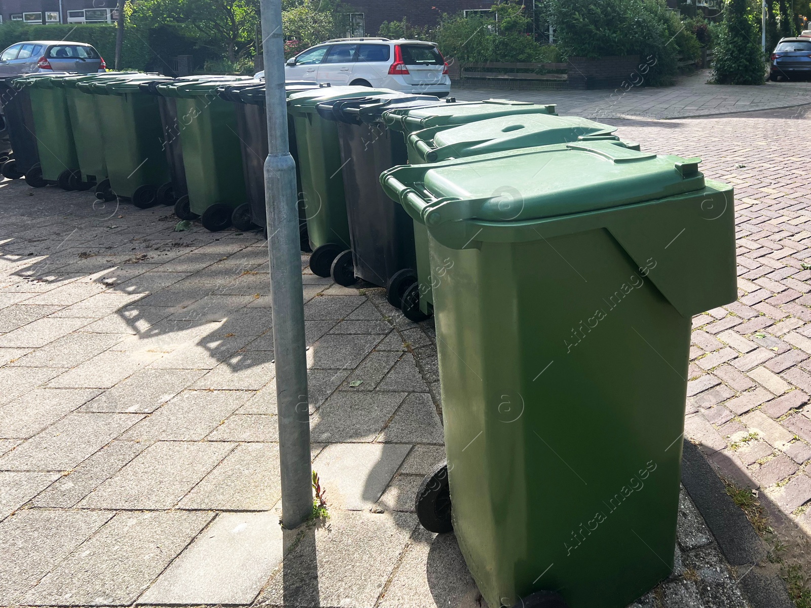 Photo of Many green trash bins on city street