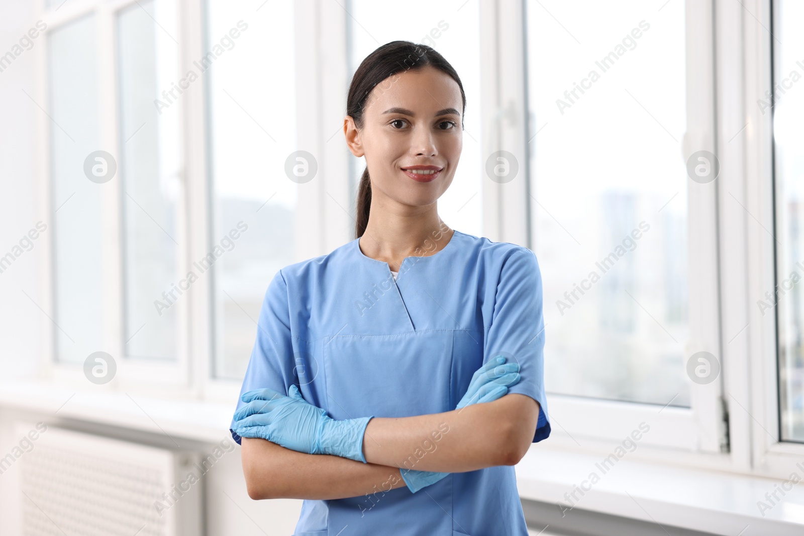 Photo of Beautiful nurse with crossed arms in clinic