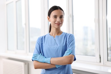 Photo of Beautiful nurse with crossed arms in clinic