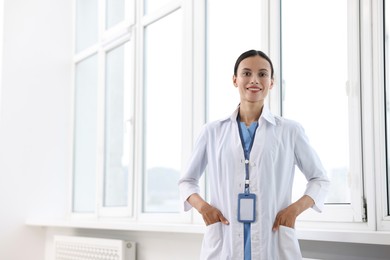 Photo of Smiling nurse near window in clinic. Space for text