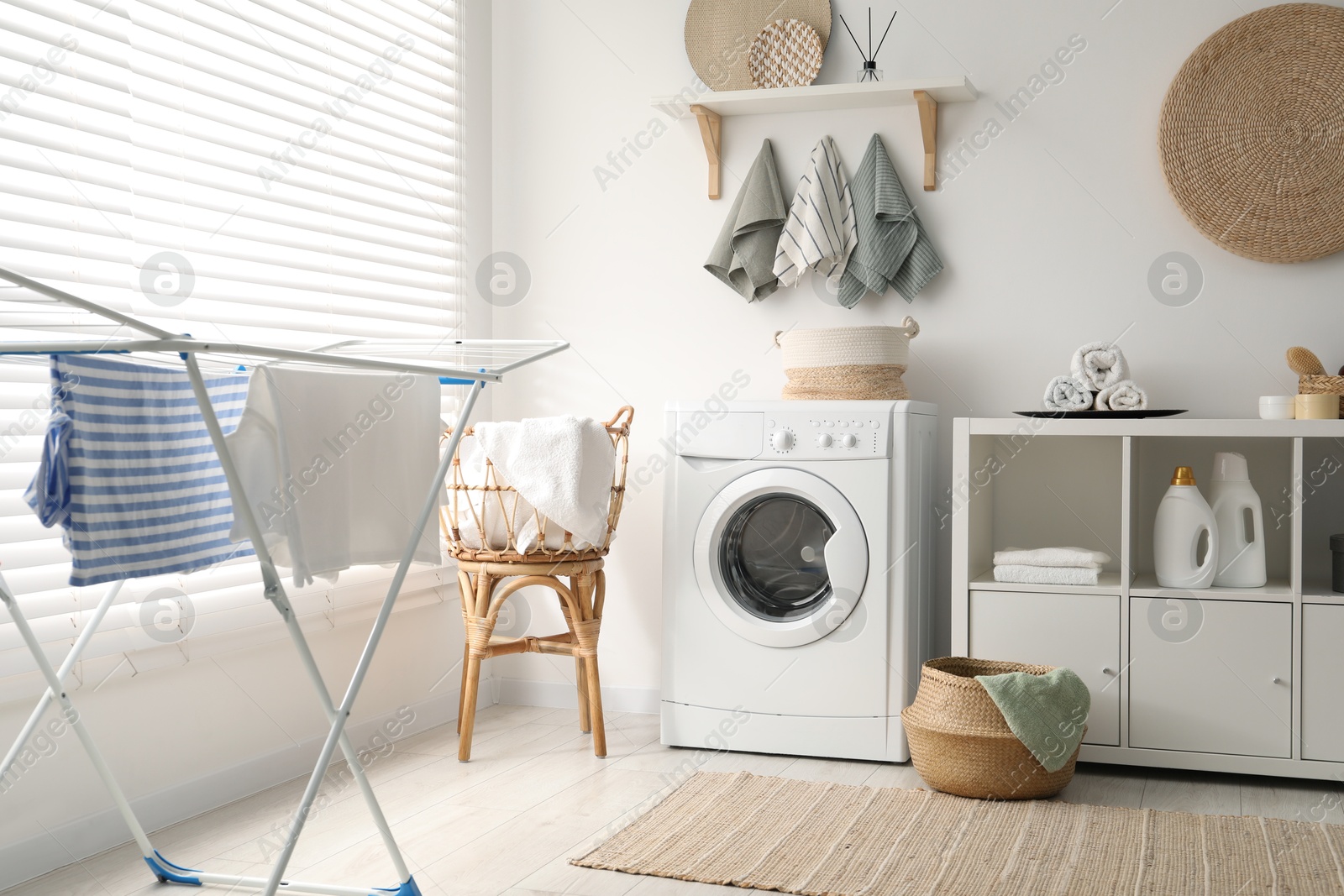 Photo of Washing machine, towels and detergents in laundry room