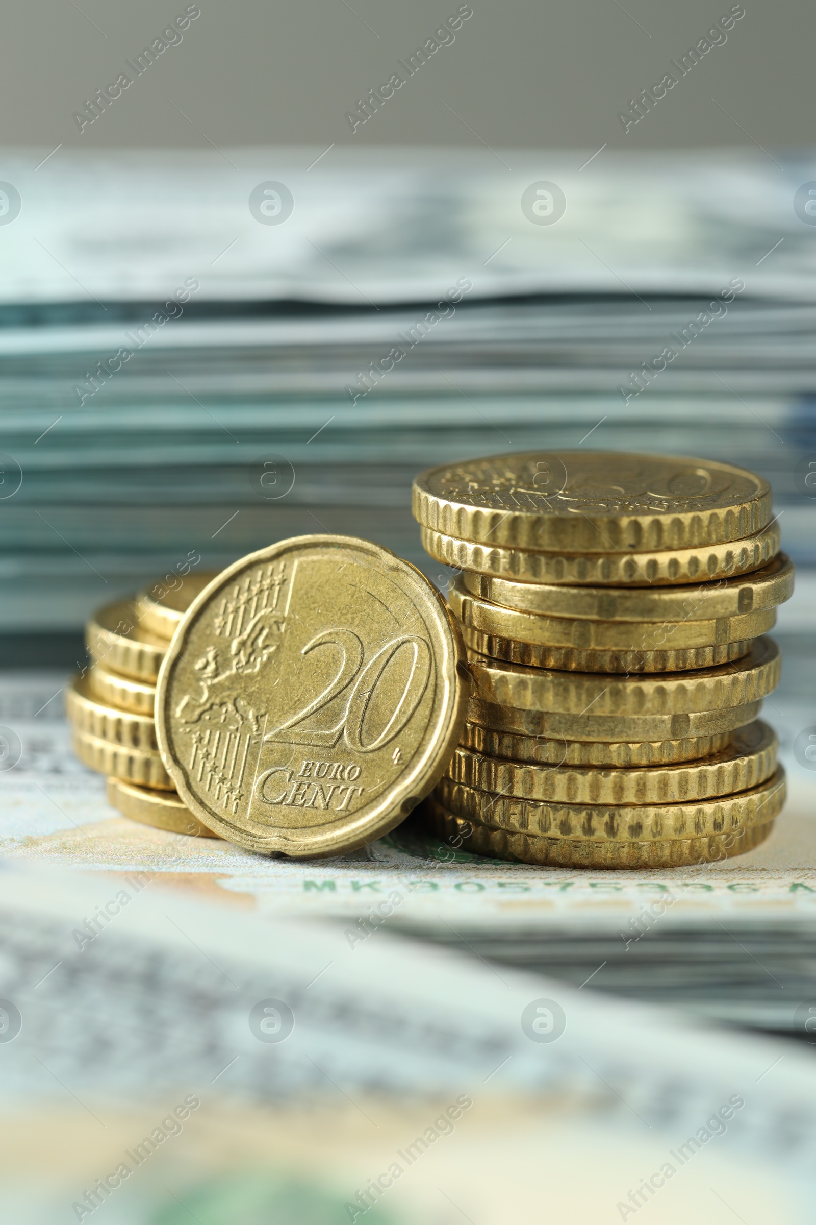 Photo of Stacked of euro coins on dollar banknotes