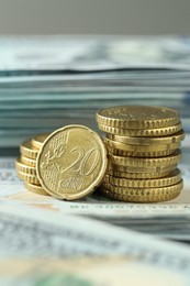 Photo of Stacked of euro coins on dollar banknotes