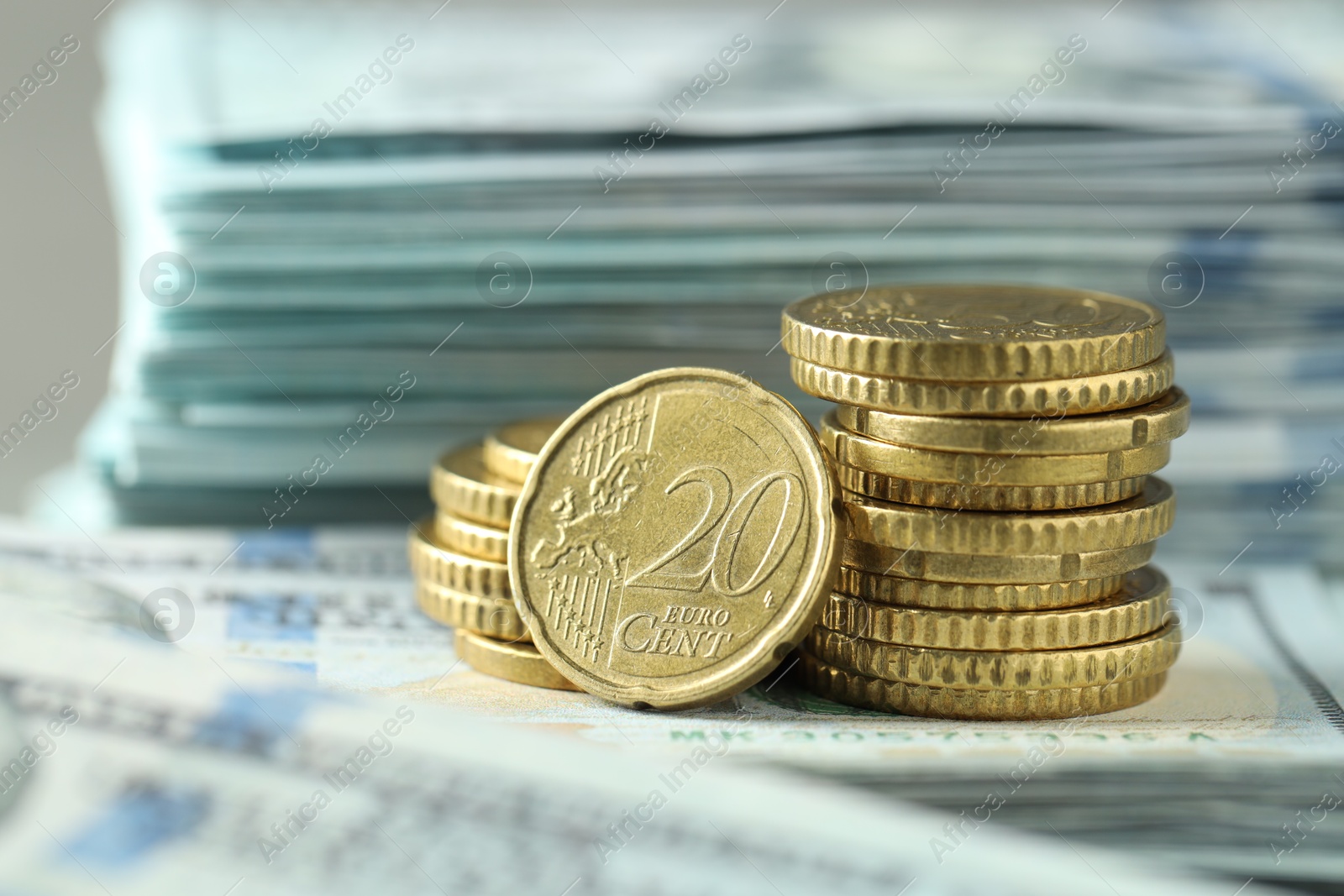 Photo of Stacked of euro coins on dollar banknotes, closeup