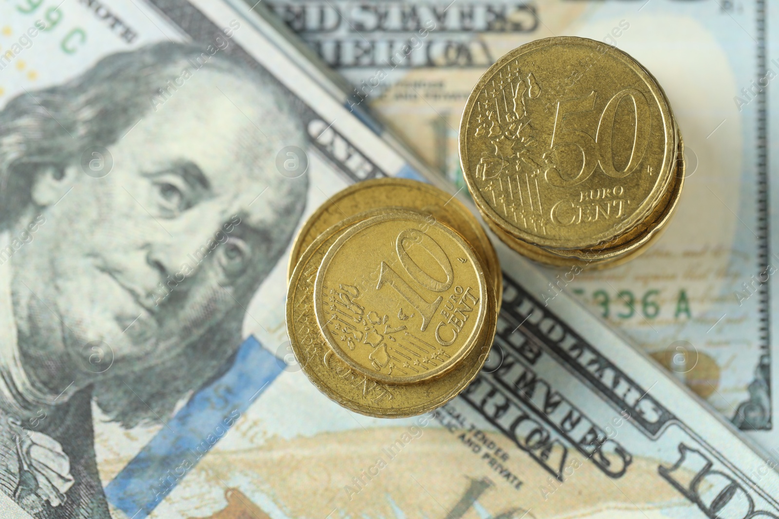 Photo of Stacked of euro coins on dollar banknotes, top view