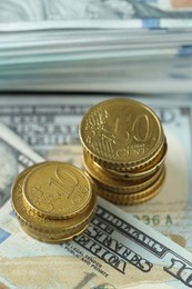 Stacked of euro coins on dollar banknotes, closeup