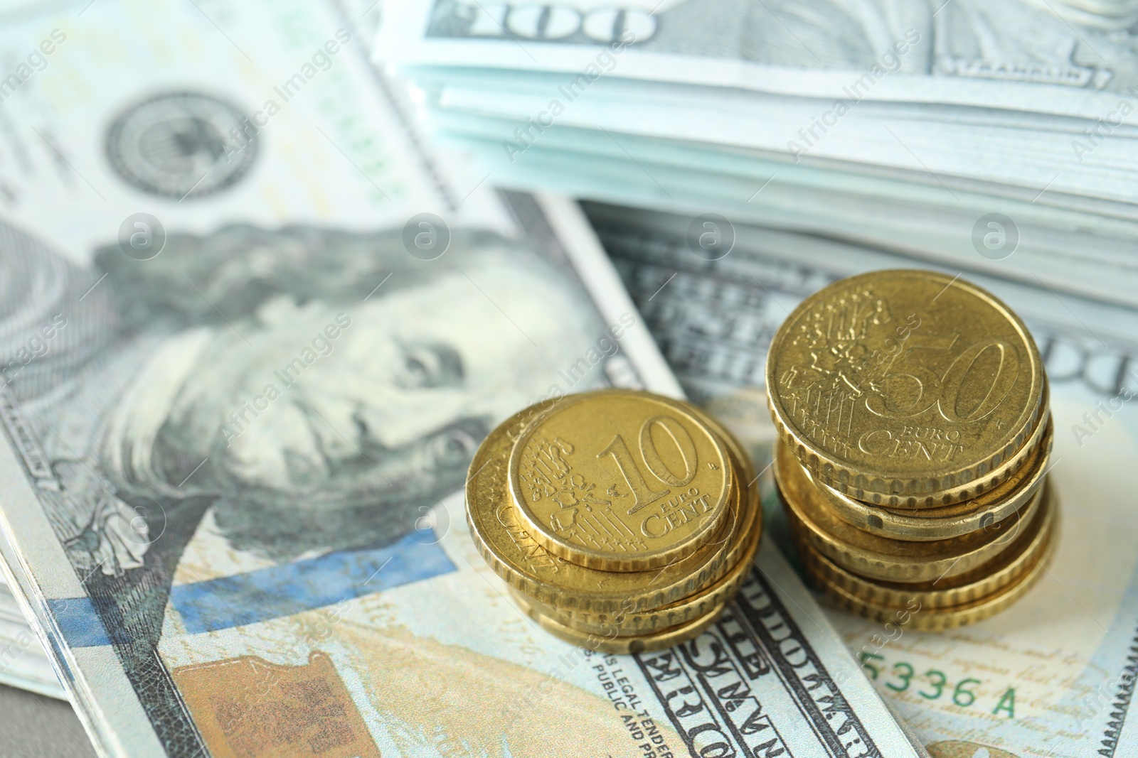 Photo of Stacked of euro coins on dollar banknotes, closeup