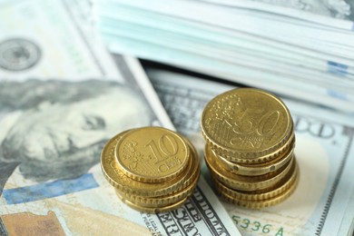 Photo of Stacked of euro coins on dollar banknotes, closeup