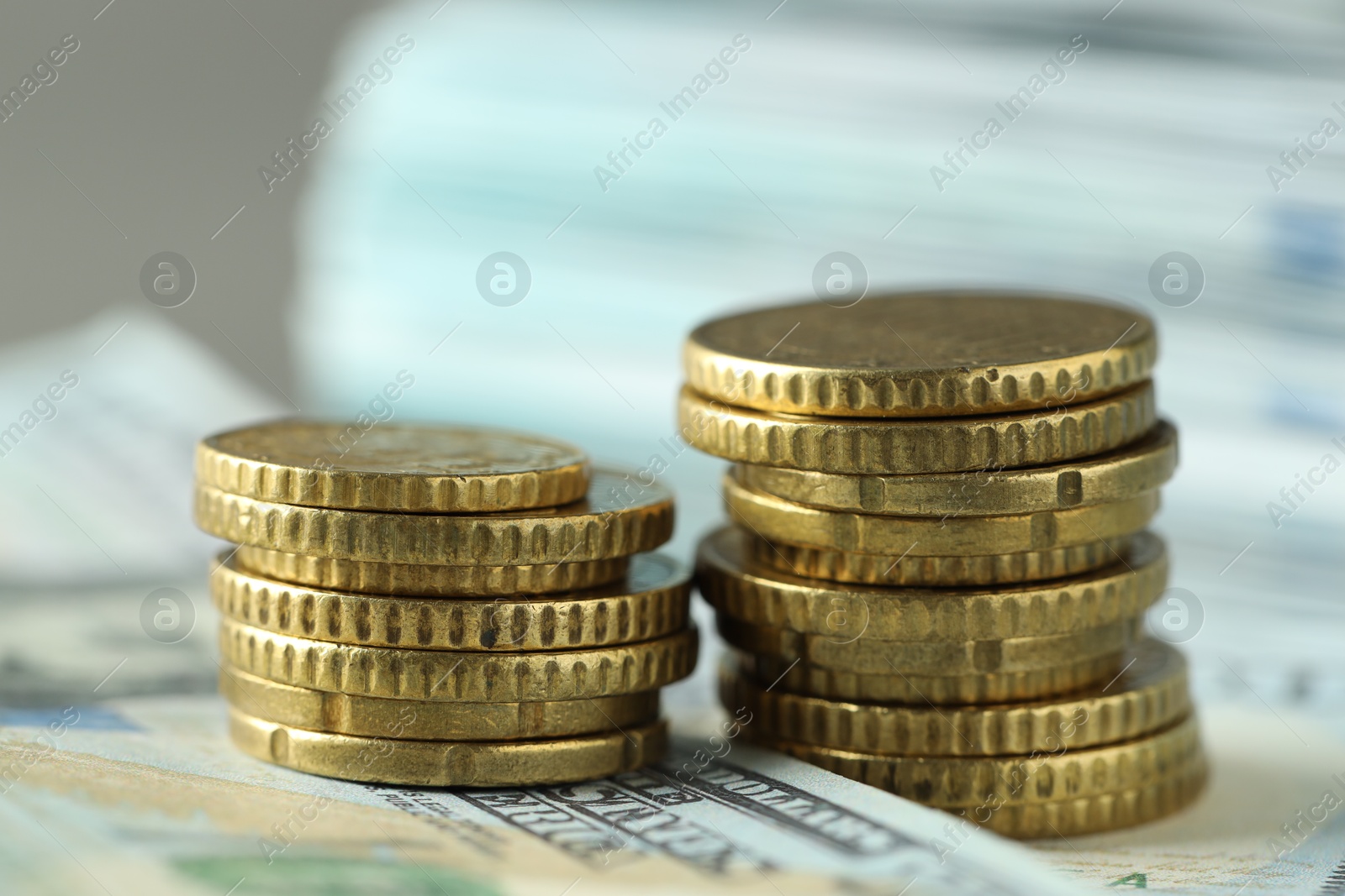 Photo of Stacked of euro coins and dollar banknotes on grey background, closeup