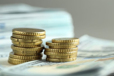 Stacked of euro coins and dollar banknotes on grey background, closeup