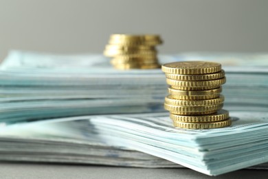 Photo of Stacked of euro coins and dollar banknotes on grey background, closeup