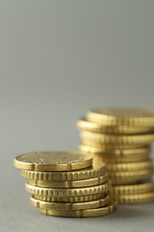 Photo of Stacks of euro coins on grey background, closeup