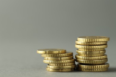 Photo of Stacks of euro coins on grey background, space for text