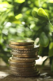 Photo of Stacked euro coins on wooden table outdoors